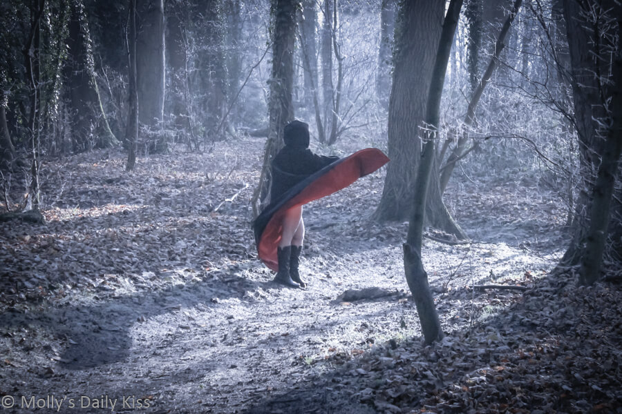 Molly in the woods in a cape for party post